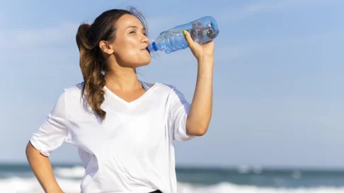 kvinna dricker vatten och blir återfuktad