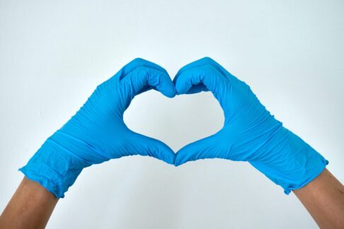 faremærkningen for æteriske olier hænder med handsker der danner et hjerte